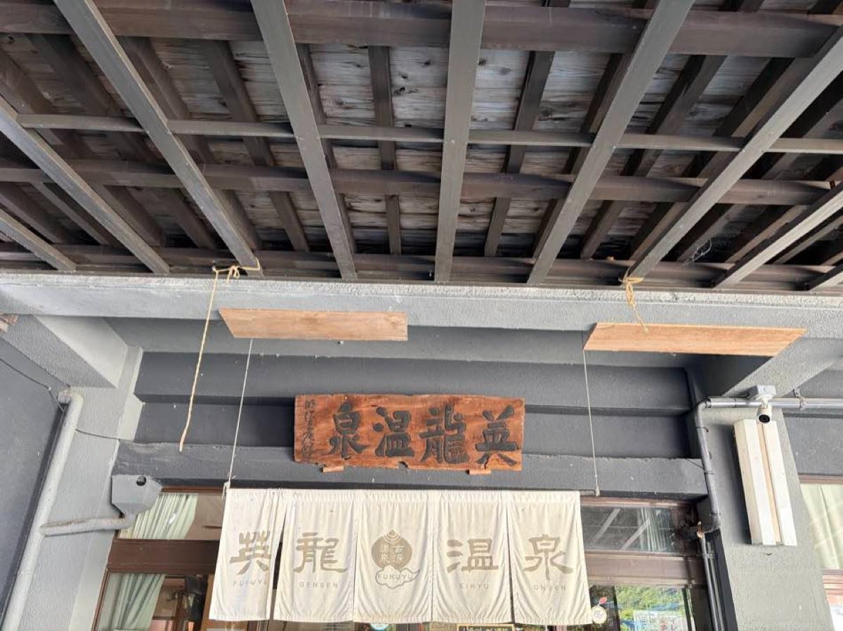 英龍温泉の入口。木の看板と暖簾
