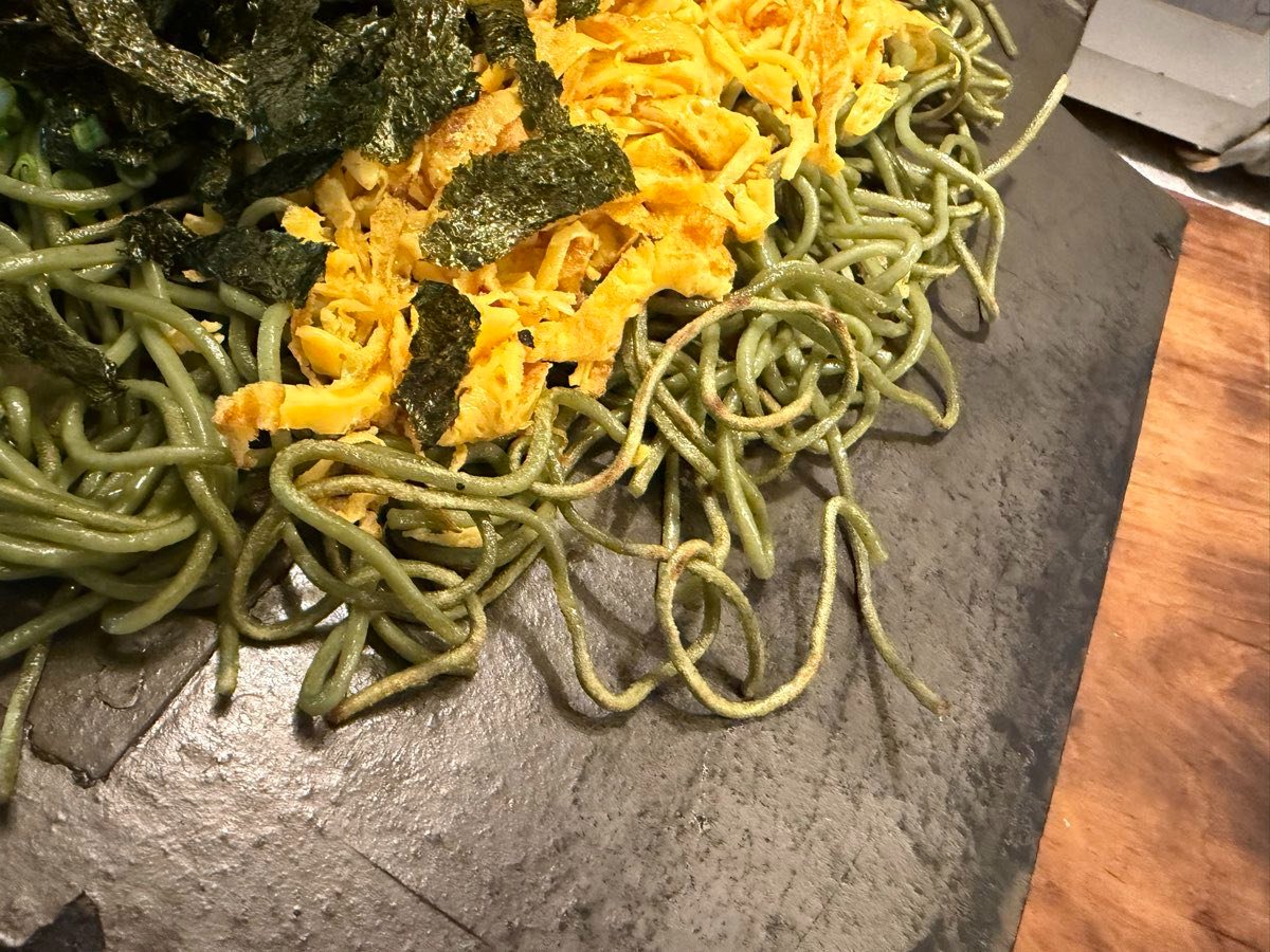瓦の上で焼かれた茶そばの麺の接写